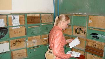 Ольга Вайцберг раскладывает свои листовки по ящикам